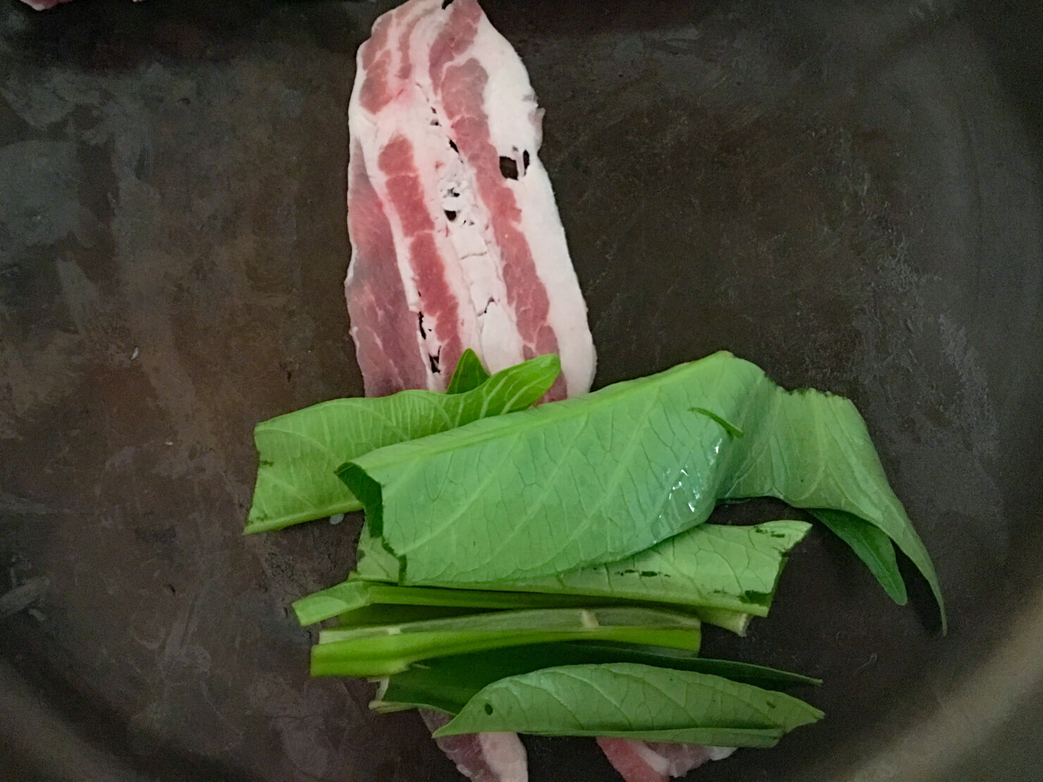 空芯菜のを豚バラで巻いている写真